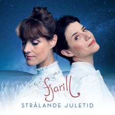 „fjarill STRÅLANDE JULETID“. Zwei Frauen in weißen Kleidern vor einem winterlichen Nacht-Hintergrund.