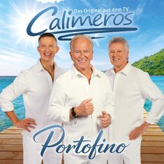 "Das Original aus dem TV, Calimeros, Portofino." Drei Männer in weißen Hemden auf einem Steg am Meer, sonnige und heitere Atmosphäre.