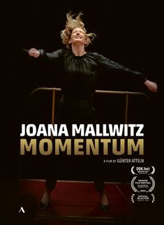 Text: "JOANA MALLWITZ MOMENTUM. A film by Günter Atteln." 
Eine Frau in schwarzer Kleidung dirigiert leidenschaftlich.