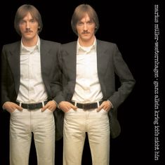 marius müller-westernhagen. ganz allein krieg ich's nicht hin. Zwei identisch gekleidete Männer vor schwarzem Hintergrund.