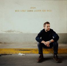 Texte: "JOSH. WER SINGT DANN LIEDER FÜR DICH." Ein Mann sitzt auf einer Bordsteinkante und schaut zur Seite.