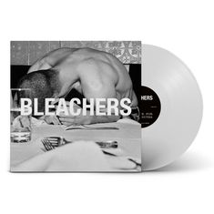 "BLEACHERS" auf einem Schwarz-Weiß-Foto eines Mannes, der über einem Tisch gebückt sitzt, mit einem Glas Wasser.