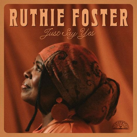 Oben steht "RUTHIE FOSTER", darunter "Just Say Yes". Eine Frau im Profil trägt ein gemustertes Tuch und große Ohrringe.