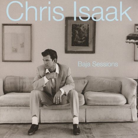 "Chris Isaak" und "Baja Sessions" in hellblauer Schrift. Schwarz-weißes Foto: Mann in Anzug auf einem Sofa.