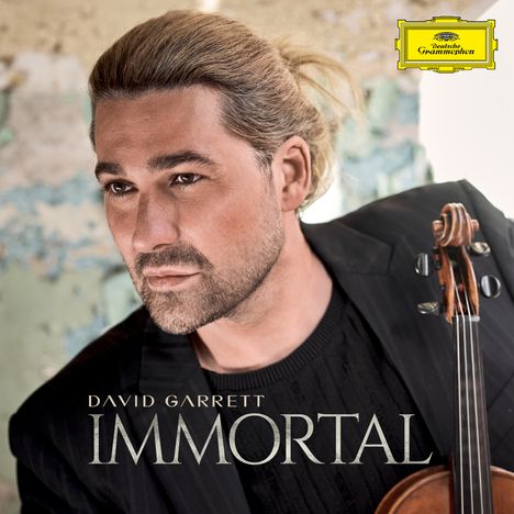 Oben steht „David Garrett“. Darunter „IMMORTAL“. Rechts: Person mit Violine, ernster Ausdruck, helles Haar, Hintergrund unscharf.