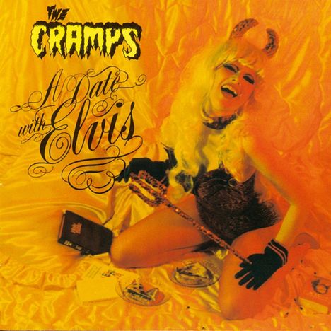 „The Cramps – A Date with Elvis“. Frau mit Teufelshörnern lacht auf gelbem Bett, hält Dreizack. Nostalgisches Rock-Thema.