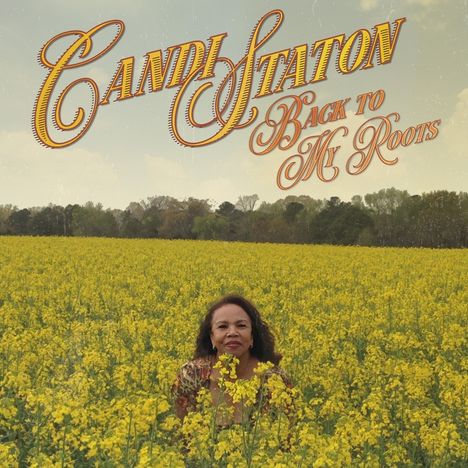 „Candi Staton: Back to My Roots.“ Eine Frau steht in einem großen Feld mit gelben Blumen. Im Hintergrund sind Bäume.