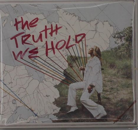 „The Truth We Hold“ in roter Schrift über einer Karte. Eine Person in Weiß sitzt auf einem Stuhl draußen.