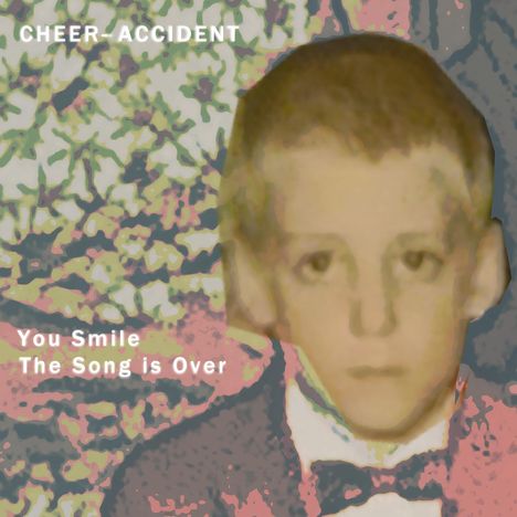 Text: "CHEER-ACCIDENT", "You Smile The Song is Over". Illustration: unscharfes Porträt eines Jungen, bunte abstrakte Muster.