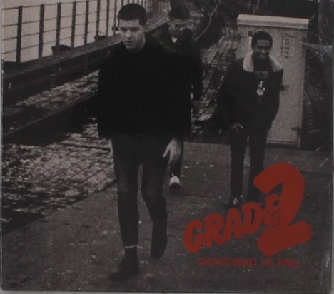 „GRADE 2 GRAVEYARD ISLAND“ steht in roter Schrift. Drei Personen gehen nebeneinander auf einem Gehweg entlang.