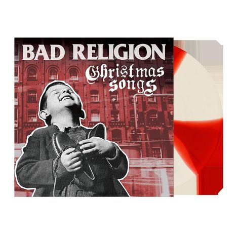 „BAD RELIGION Christmas Songs“ steht über einem lachenden Kind mit Schuhen, vor rotem Gebäude.