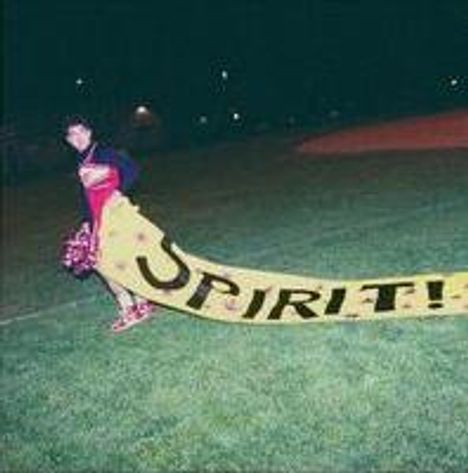 Das Bild zeigt eine Person auf einem Sportfeld, die ein gelbes Banner mit der Aufschrift "SPIRIT!" über den Rasen zieht.