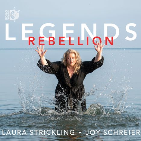 Text: "LEGENDS REBELLION, LAURA STRICKLING • JOY SCHREIER". Eine Frau im schwarzen Kleid spritzt Wasser auf.