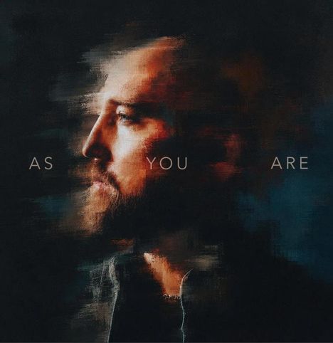 „AS YOU ARE“ steht in einem unscharfen Gemälde eines nach links schauenden Mannes mit Bart, warmen Farben umgeben ihn.