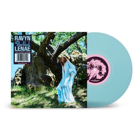 "RAVYN LENAÈ, Blue Island, THE THIRD ALBUM." Eine Frau in einem blauen Kleid steht vor einem großen Baum. Links eine Vinyl-Schallplatte.