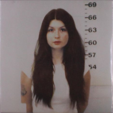 Höhenmarkierungen: 54 bis 69. Junge Frau mit langen, dunklen Haaren und einem tätowierten Arm, trägt ein weißes Oberteil.