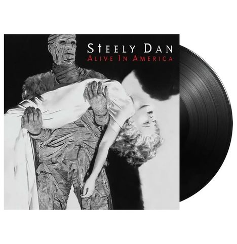 Texte: "Steely Dan Alive In America". Eine Mumie trägt eine bewusstlose Frau in einem dramatischen Schwarz-Weiß-Stil.