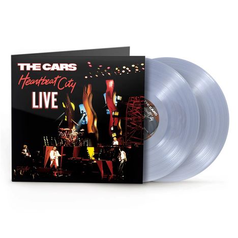 "The Cars", "Heartbeat City", "Live" - Konzertaufnahme Bühne in leuchtenden Farben, Band spielt Musik.