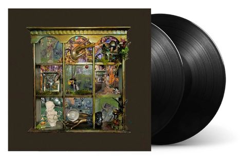 Ein kunstvolles Regal mit verschiedenen Objekten, wie Instrumenten, Pflanzen und Statuen. Daneben zwei schwarze Vinyl-Schallplatten.