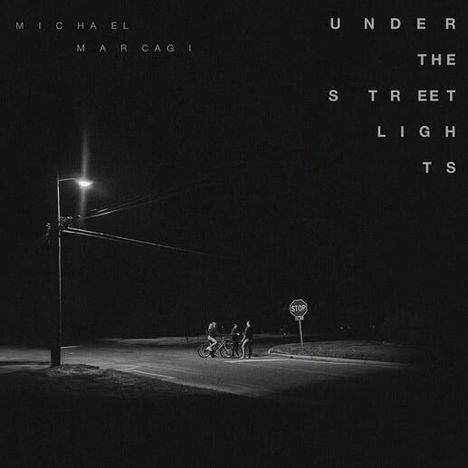Texte: "Michael Marcagi", "Under the Streetlights". Eine schwach beleuchtete Straßenecke mit drei Personen und einem Stoppschild.