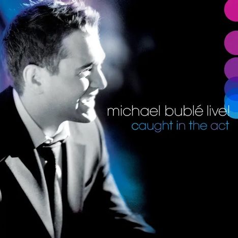 "michael bublé live! caught in the act" in weißer und blauer Schrift. Mann in Anzug, seitlich lächelnd, rechts bunte Kreise.