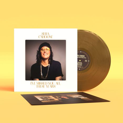 Aufschrift: "SERA CAHOONE, I'VE MISSED YOU ALL THESE YEARS". Coverfoto von Person mit Brille und Mütze. Goldene Schallplatte.