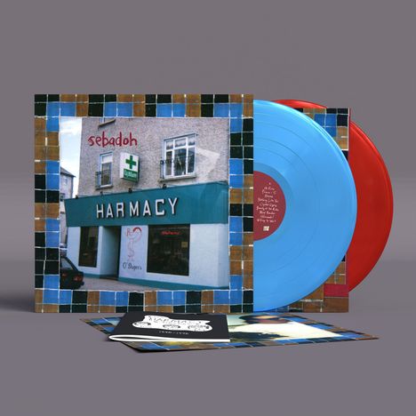 "sebadoh HARMACY" steht auf einem Plattenalbumcover. Zwei bunte Vinyl-Schallplatten in Blau und Rot sind sichtbar.