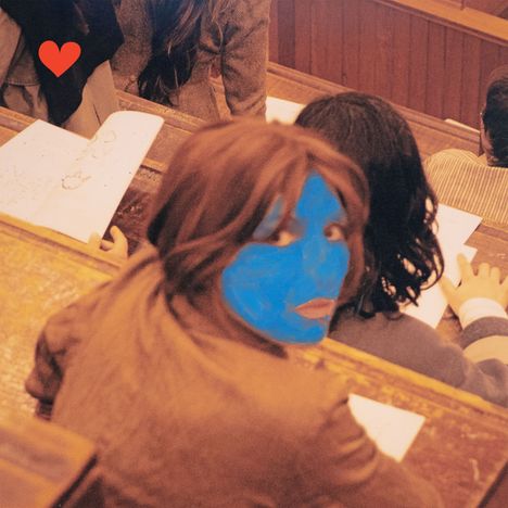 Illustration: Eine Person dreht sich in einem Hörsaal um, mit blau bemaltem Gesicht. Ein rotes Herz ist oben links.