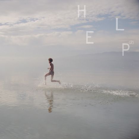 Text: "HELP". Junge läuft im flachen Wasser, Spritzer um ihn, Hintergrund aus Himmel und Wolken.