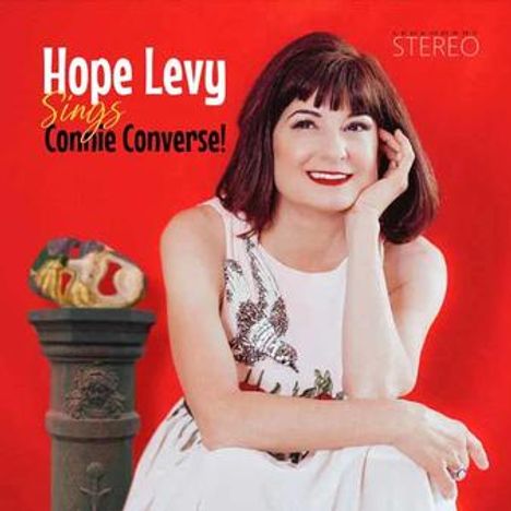 „Hope Levy sings Connie Converse!“ in weißem und orangem Text. Frau in weißem Kleid, roter Hintergrund.