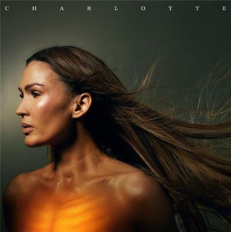 Text "CHARLOTTE" oben. Frau mit wehendem Haar, bronzefarbene Haut, leuchtet leicht orange im Brustbereich.
