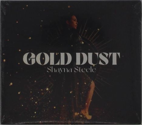 "GOLD DUST" und "Shayna Steele" in großen, markanten Buchstaben. Eine Frau in elegantem Schwarz mit goldenen Lichtpunkten.