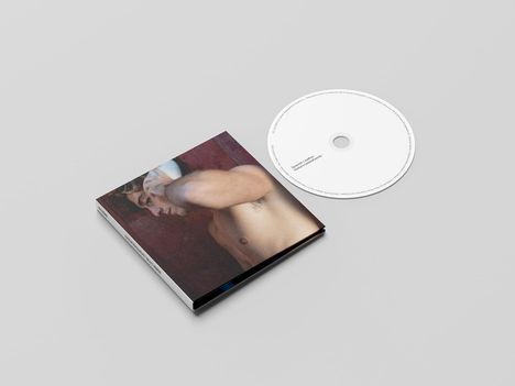 CD mit „Deluxe Leather Embossed Packaging“-Text, daneben ein geschlossenes CD-Cover mit dem Bild eines Mannes.