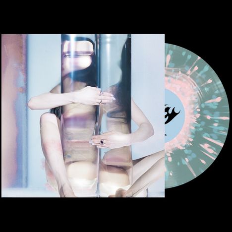 Text auf Vinyl: "wrecky". Eine Frau umarmt zwei reflektierende, zylindrische Objekte. Farbspritzer-Vinyl im Hintergrund.