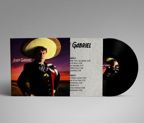 Juan Gabriel steht in traditioneller Kleidung vor einem Sonnenuntergang. Links steht sein Name. Ein schwarzes Vinyl ist zu sehen.