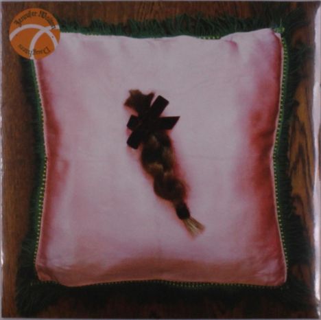 Oben links steht „Tangerine Dream“. Ein geflochtener Zopf liegt auf einem rosa Kissen mit grüner Fransenbordüre.