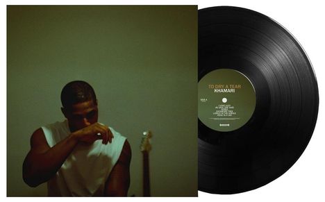 „TO DRY A TEAR, KHAMARI, SIDE A“ auf einer Schallplatte. Ein Mann in einem weißen Shirt hält seine Hand vors Gesicht.