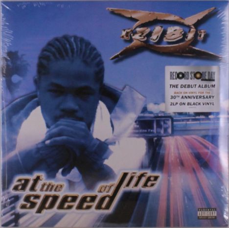 Text: "at the speed of life", Sticker: "RECORD STORE DAY, THE DEBUT ALBUM, 30TH ANNIVERSARY, 2LP ON BLACK VINYL." Vordergrund: Person mit gefalteten Händen.