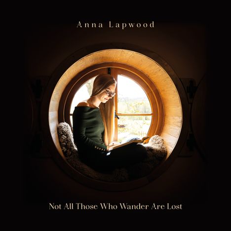 "Anna Lapwood: Not All Those Who Wander Are Lost." Eine Frau sitzt lesend in einem runden Fensterrahmen.