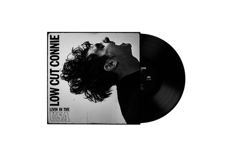 „LOW CUT CONNIE“ und „LIVIN IN THE USA“. Ein Profilfoto eines Mannes mit nach hinten geworfenem Kopf. Schallplatte.