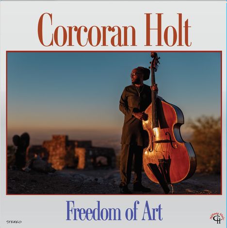 "Corcoran Holt", "Freedom of Art". Person mit einem Kontrabass im Freien bei Sonnenuntergang, Gebäude im Hintergrund.
