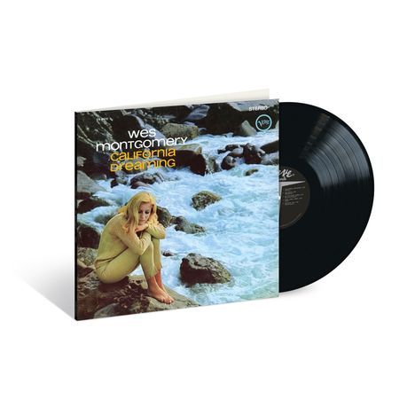 "Wes Montgomery, California Dreaming." Eine Frau in gelbem Outfit sitzt nachdenklich an einem felsigen Flussufer.