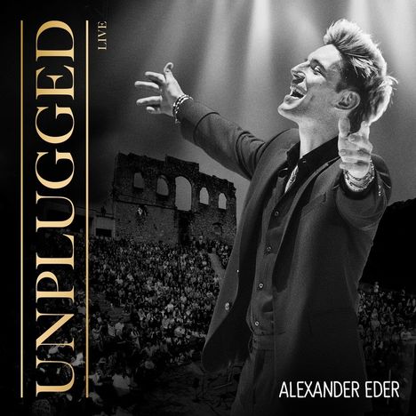 Unplugged Live, Alexander Eder. Jubelnder Mann in einem Anzug vor einer Menschenmenge und alten Ruinen.