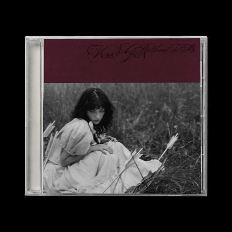 Text: "Violet Grohl - Be Sweet To Me". 
Schwarz-weiß Foto einer Frau in einem langen Kleid auf einem Feld sitzend.