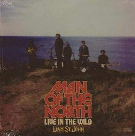 „MAN OF THE NORTH, LIVE IN THE WILD, LIAM ST. JOHN.“ Eine Band steht auf einer Klippe am Meer.
