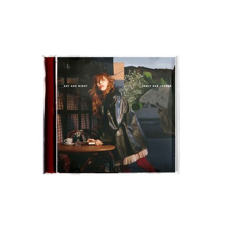 "DAY AND NIGHT", "CARLY RAE JEPSEN". Eine Frau lehnt sich in einem Café an einen Tisch; trägt eine schwarze Lederjacke.