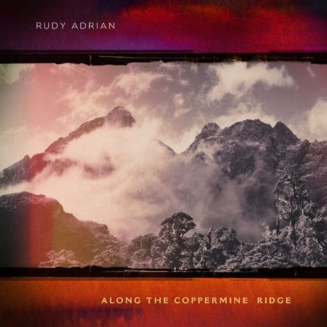 "Rudy Adrian" und "Along the Coppermine Ridge" auf einem stimmungsvollen Berglandschaftsfoto mit Wolken und Bäumen.