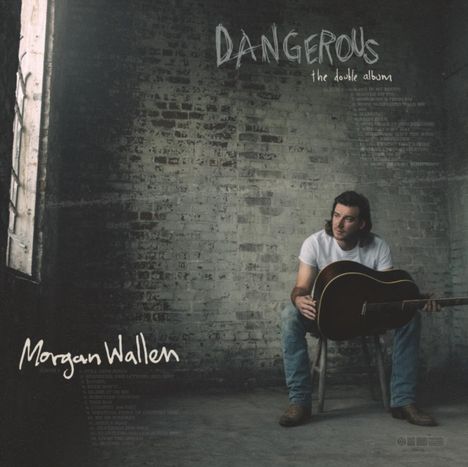 "DANGEROUS the double album", darunter ein Mann auf Stuhl mit Gitarre vor grauer Wand, trägt weißes Shirt und Jeans.