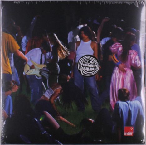 „Le Premier Album“ auf einem kreisförmigen Emblem. Junge Menschen tanzen auf einer Party im Freien.