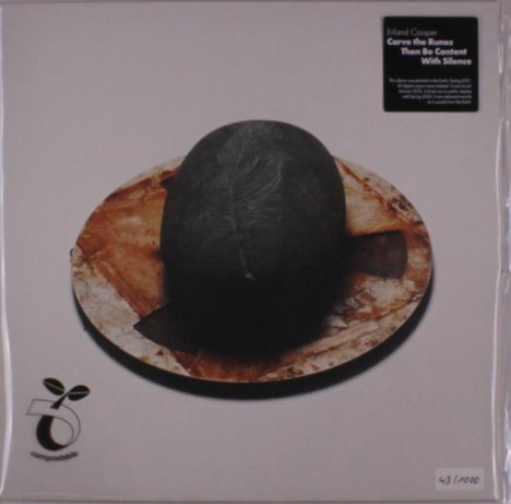 "Erland Cooper - Carve the Runes Then Be Content With Silence." Logo: Pflanze über rundem Symbol. Dunkler Stein auf braunem Teller.